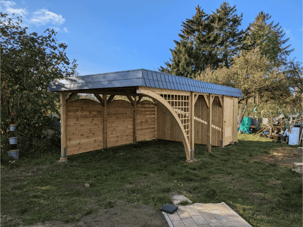 Bogenpfosten Carport von Brüning Carports mit Schindelblende Schuppen und Ziergitter errichtet von Holzbau K. Jager
