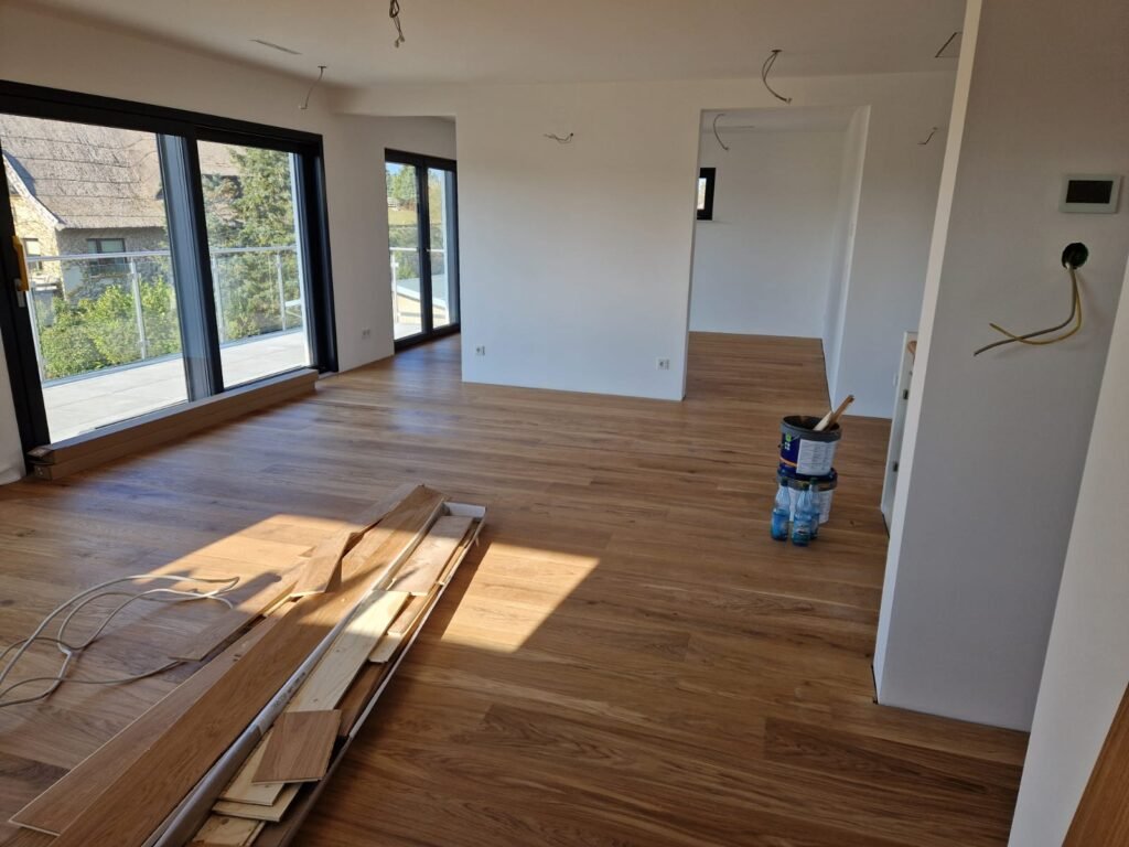 Fensterfront wirft warmes Licht auf naturholzfarbenen Vinylboden