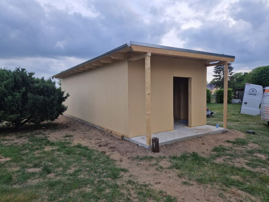 Gedämmte Fassade des Gästehauses mit Haustür und überdachtem Eingang